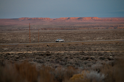 That evening, I watched the sun set, coating the landscape in a pink glow, watching the cars and trucks pass by. 